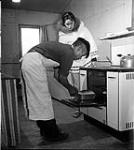[Alma Houston with a baker, Kinngait, Nunavut]. [between 1956-1960]