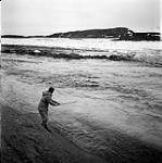 [Barbara Hinds fishing on a rock in the Sylvia Grinnell River, Iqaluit, Nunavut]. [between 1956-1960]