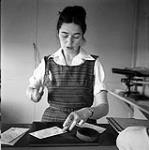 [Alma Houston preparing letters, Kinngait, Nunavut]. [between 1956-1960]