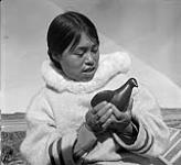 [Woman [Qaunaq Mikkigak] holding a bird sculpture, Kinngait, Nunavut]2  [between 1956-1960]