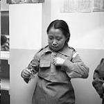 [A Brownie putting on her uniform, Iqaluit, Nunavut]. 1960