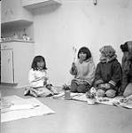 [Group of Girl Guides and Brownies pressing wildflowers, Iqaluit, Nunavut]. 1960