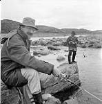 [Mackenzie Porter (left) and a man fishing, Iqaluit, Nunavut]. 1960