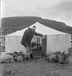 [Mackenzie Porter opening a door to a tent, Iqaluit, Nunavut]. 1960