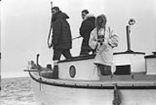 [James Houston (left) and two men on a boat]. 1960