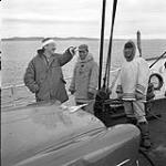 [Mackenzie Porter (left) and two men standing on a boat, Iqaluit, Nunavut]. 1960