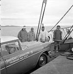 [Mackenzie Porter (left) and three men standing on a boat, Iqaluit, Nunavut]. 1960