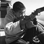 [Sarpinak holding a rifle, Iqaluit, Nunavut]. 1960