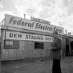 [Clarence Rudolf Clare Dobbin standing in front of the Federal Electric Corp. Dew Staging Office building, Iqaluit, Nunavut]. 1960