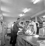 [Barbara Hinds (right) purchasing equipment at the HBC store, Niaqunngut, Iqaluit, Nunavut]. 1960