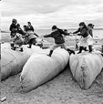[Kids playing on packed Hudson's Bay Company canoes, Iqaluit, Nunavut]. 1960