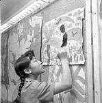 [Lucy Evaluardjuk painting in a classroom, Iqaluit, Nunavut]. 1960
