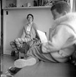 [Alma Houston sitting with her son inside, Kinngait, Nunavut]. 1960