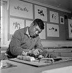 [Iyola Kingwatsiak making a print, Kinngait, Nunavut]. 1960