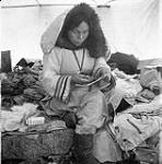 [Napatchie Pootoogook sewing a belt inside a tent, Kinngait, Nunavut]  1960