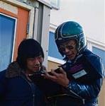 Deux hommes, dont l'un porte un casque, à Arviat 1979.