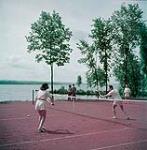 Man and woman playing tennis at Hovey Manor, Lake Massiwippi, Québec. July 1950