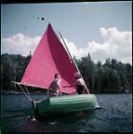 Sailing a gaff-rigged dinghy on Canoe Lake, Algonquin Park, Ont.  July 1951.