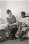 [Alma Houston and an elderly Inuk woman examine a garment]. [between 1955-1963]