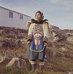 Woman [identified as Quuju Ottokie] wearing beaded clothing at [Kinngait] (Cape Dorset), Baffin Island, [Nunavut] [in July 1961]  July 1961