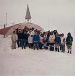 Des inuits avec le révérend Leslie Corness et l'évêque, le révérend Donald B. March, à l'extérieur de l'école de la baie Frobisher  mai 1958.