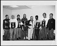 Les membres du groupe Hootie and the Blowfish, tenant dans leurs mains des prix remis par Warner Music Canada pour le million de copies vendues de l¿album « 'Cracked Rear View » : (de gauche à droite) Herb Forgie (Warner), Dean Felber (du groupe), Steve Waxman (Warner), Jim Stonefield (du groupe), Garry Newman (Warner), Darius Rucker (du groupe), Mark Bryan (du groupe), Doug Raaflaub (Warner) - Toronto  ca. 1994.