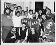 Honeymoon Suite and friends celebrating their Platinum Album award after a show at Maple Leaf Gardens, Toronto: (front row) Larry Green (WEA Nat. Promo), Dave Tollington (WEA Domestic Label Mgr.), JoAnn Kaeding (WEA Publicity), (back row) Pat Arnet, Jeff Rodgers (Head Office mgmt.), Garry Newman (WEA VP Sales), Bob Roper (WEA A&R), Ray Coburn, Roger Desjardins (WEA Artist Relations), Johnny Dee, Derry Grehan, Dave Betts, Gary Lalonde, Steve Prendergast (Head Office mgmt.) [ca. 1984].