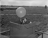 Meteorology observer checks bearings on theodolite before releasing pilot balloon which gives speed and direction of upper air currents  September 16, 1940