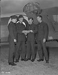 Four Leading aircraftmen, J.W. Dean [Doan], P.E. Milward, H.H. Miller, and A.J.B. Monk, in front of an aircraft at No. 8 Elementary Flying Training School in Vancouver, British Columbia  September 30, 1940
