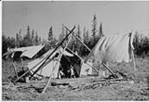 Three children standing in entrance of tent, Fort Norman, Northwest Territories. n.d.