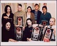 Photographie instantanée des membres du groupe Marilyn Manson recevant un prix platine pour leur album "AntiChrist Superstar". En haut, de gauche à droite: Zim Zum; Ginger Fish; Ann Brubaker, Interscope; Randy Lennox, MCA et Tony Ciulla, gérant du groupe. En bas, de gauche à droite: Twiggy Ramirez, Monsieur Manson et Pogo. [entre 1996-1997]