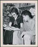 Nola Unruh reading with a boy in a bookmobile from the Middlesex County Library, Ontario n.d.