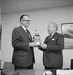 Bill Emerson presenting a trophy to Pierre Dupuy of the Canadian Travel Ass. [Association]. September 18, 1967
