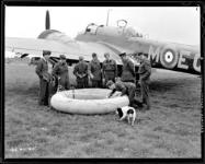 Members of a Canadian bomber Squadron in England look over an inflated "Dinghy" W/C N.W. Timmerman, P/O T.W. Dench, Cpl. Bangs, F/O Houston, F/L A. Clayton, G/C R.T. Taaffe and S/L H. Fowler  12 August 1941.