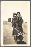 [Inuk woman in fur clothing, carrying a baby on her back]  [ca. 1903]