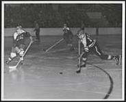 [Walpole Island and Parry Island juvenile hockey players playing in a tournament, one boy is getting ready to hit the puck]. 1967