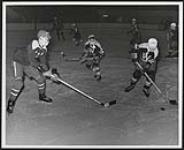 [Walpole Island and Parry Island juvenile hockey players playing in a tournament, one boy is getting ready to hit the puck]. 1967