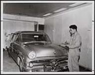 Wesley Hart of the Fisher River Reserve in Manitoba is seen here at work in the shop of the Modern Auto Body Repair company in Selkirk. [ca. 1960]
