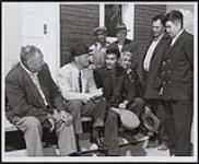 [Senator James Gladstone, (second from left) chats with a group of Cree in the Fisher River Agency which he visited recently]. Original title: Senator James Gladstone, Canada's first Indian Senator, (second from left) chats with a group of Indians in the Fisher River Agency which he visited recently. 1958