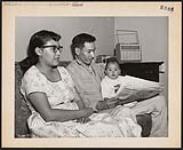[Daniel Eaglechild, 30 is a Kainai (Blood) who works as a carpenter in Edmonton. Seen here with his wife Elsie and daughter]. Original title: Daniel Eaglechild, 30 is a Blood Indian working as a carpenter in Edmonton. [between 1900-1976]