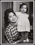 [Happily settled in Vancouver, Mrs. Robert Cantryn, president of Coqualeetza Fellowship, helps First Nations people who come to Vancouver. Her husband is a member of the organization but their year-old daughter, Roberta, is a little young yet for this privilege]. Original title: Happily settled in Vancouver, Mrs. Robert Cantryn, president of Coqualeetza Fellowship, helps Indian people who come to Vancouver. Her husband is a member of the organization but their year-old daughter, Roberta, is a little young yet for this privilege. 12 January 1960
