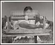 [Woman spinning wool for use in Cowichan wool sweaters and other knit wool goods, a specialty of the Salish women]. Original title: Woman spinning wool for use in Cowichan wool sweaters and other knit wool goods, a specialty of the Salish Indians  1960.