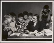 Boys of grade 3 and 4 get help from teacher Miss Irene Reesor. [between 1900-1976]
