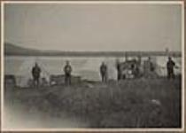 [Personnel of the Hamilton Inlet Expedition of the Tidal and Current Survey in camp. (Left to right); Messrs. G.L. Crichton, A.C. Abbott, H.W. Jones, unidentified Indigenous peoples, Messrs. Hopkins, Carroll.] Original title: Personnel of the Hamilton Inlet Expedition of the Tidal and Current Survey in camp. (Left to right); Messrs. G.L. Crichton, A.C. Abbott, H.W. Jones, unidentified natives, Messrs. Hopkins, Carroll.   July 4 -  September 2, 1923.