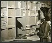 The Tashme, B.C. camp post office. Japanese employees sort and distribute the mail. [1943/11-1943/12]