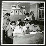High school students at Christina Lake, Alberta, study their University of British columbia correspondence courses under the supervision of a grade school instructor. [1945/06/16-1945/06/28]