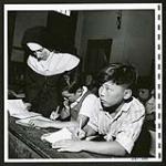 Nuns do all the instructing of classes, included grade classes, business courses nad typing, at the Catholic church school in Greenwood. [1/2]. [1945/06/16-1945/06/28]