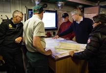 [Prime Minister Stephen Harper and Leona Aglukkaq are briefed by Ryan Harris, Parks Canada, aboard the HMCS Kingston prior to participating in part of the 2014 Search for Franklin Expedition along the Northwest Passage] 24 August 2014
