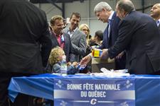 [Prime Minister Stephen Harper hands out boxed St. Hubert lunches while at Centre Caztel in Quebec to celebrate Saint-Jean-Baptiste Day] 24 June 2015
