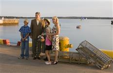 [The character Anne of Green Gables, portrayed by actress Laura Dunn, poses for a photo with Canada's Prime Minister Stephen Harper, son Ben, daughter Rachel and wife Laureen Harper during a Tory caucus barbecue in Charlottetown, Prince Edward Island] 1 August 2007